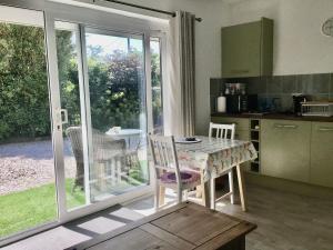 a kitchen with a table and chairs and a kitchen with sliding doors at Wadebridge Whitecross studio 1 in Wadebridge