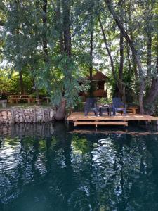 a table and chairs sitting on a dock in a pond at FortUNA Holiday Home in Bihać