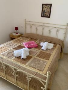a bed with two pillows and towels on it at Villa Pineta in San Menaio