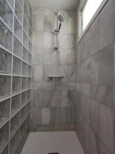 a shower with a shower head in a bathroom at Room near the sea in Marbella