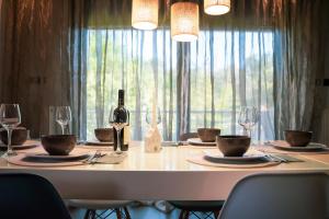 uma mesa branca com uma garrafa de vinho e copos em Olea Residence Palio em PalaiónTsiflíkion