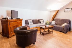 ein Wohnzimmer mit 2 Stühlen und einem TV in der Unterkunft Maison Calme 14 personnes, piscine, jardin et parking in Buchères
