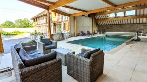 einen Pool mit Korbstühlen und einem Tisch in der Unterkunft Maison Calme 14 personnes, piscine, jardin et parking in Buchères