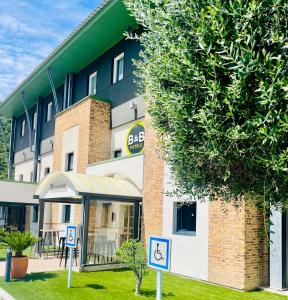 a building with a disabled sign in front of it at B&B HOTEL Aubagne G&eacute;menos in G&eacute;menos