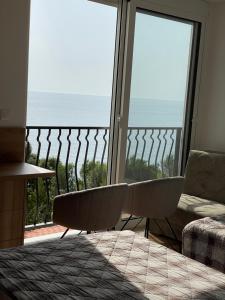 a room with a balcony with a view of the ocean at Hotel R in Utjeha