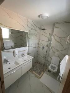 a bathroom with a sink and a shower and a toilet at Hotel R in Utjeha