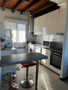 una cucina con armadi bianchi, tavolo e sedie di Appartement pour famille Saint-Pierre-la-Mer a Fleury