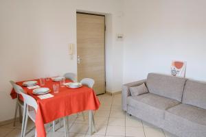 uma sala de estar com uma mesa e um sofá em Magico Apartments - 450m dalla spiaggia em Capo dʼOrlando