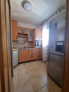 een keuken met houten kasten en een roestvrijstalen koelkast bij Apartman Bruna in Zagreb