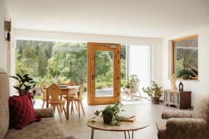 a living room with a table and a glass door at Untermairhof Appartment Residence in Selva dei Molini