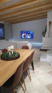 a living room with a wooden table and a tv at AQUA VILLA in Selínia