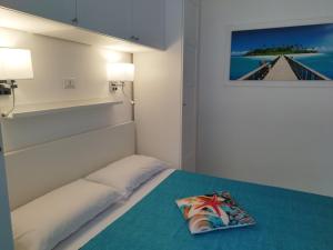 a bedroom with a bed with a pillow on it at SoleMare Rooms "Smeraldo" in Procida