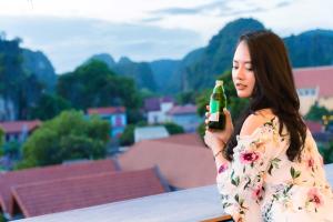 a woman is holding a bottle of wine at Tam Coc Moment Homestay in Ninh Binh