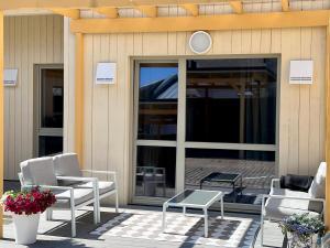 a patio with chairs and a table and glass doors at Saue Apartment in Haapsalu