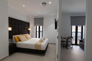 a bedroom with a bed and a room with a table at Suites Puerto Valencia in Valencia