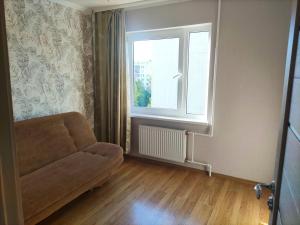uma sala de estar com um sofá e uma janela em Julias Apartments Riga, 3x rooms em Riga