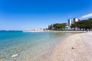 a beach with the ocean and buildings in the background at Holiday house VIDA in Biograd na Moru