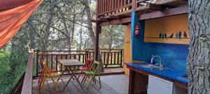 a kitchen with a sink and a table on a deck at TreeHouses Ljubač Glamping Robinson in Ljubač