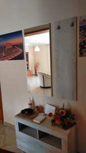 Habitación con espejo y mesa con flores en La Perla dei Templi, en Agrigento
