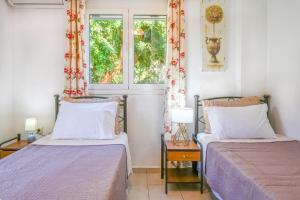 two beds in a room with a window at Charalampos in Plakias