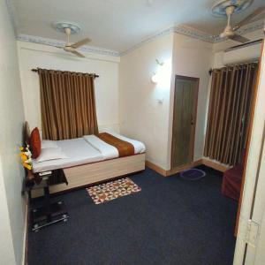 Tulip 1bhk Apartment by Hotel Airways في كولْكاتا: غرفة نوم صغيرة بها سرير ونافذة