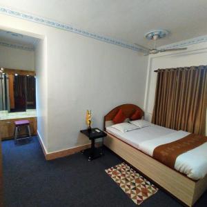 um quarto com uma cama, uma mesa e uma janela em Tulip 1bhk Apartment by Hotel Airways em Calcutá