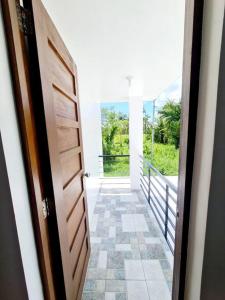 a door to a hallway with a view of a balcony at Elon's Place in Catarman