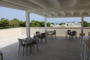 a patio with tables and chairs on a roof at Coral Sand bed and breakfast in San Vito lo Capo
