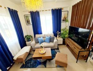 ein Wohnzimmer mit Sofa und Flachbildfernseher in der Unterkunft Elon's Place in Catarman
