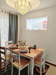 a dining room table with chairs and a chandelier at Elon's Place in Catarman