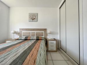 1 dormitorio con 1 cama grande y mesita de noche en Primera línea con piscina en Calpe, en Calpe