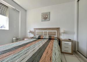 Un dormitorio con una cama grande y una ventana en Primera línea con piscina en Calpe, en Calpe