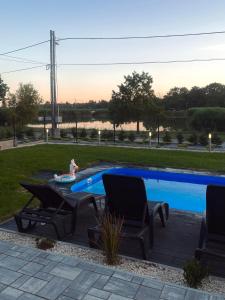 a child is playing in a swimming pool with two chairs and a girl sitting in at Lux apartments in Orosháza