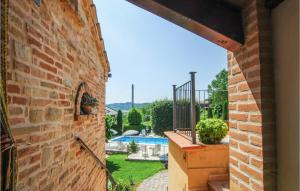 a brick building with a view of a pool at Cozy Apartment In Monte Rinaldo in Monte Rinaldo