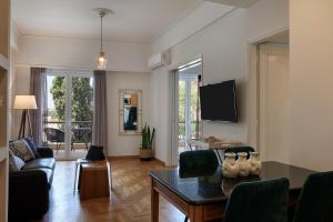 een woonkamer met een bank en een tafel bij Chic One Bd Apartment with Hilton View in Athene