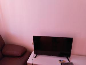 a flat screen tv sitting on a table next to a couch at Apartment Victory Second in Pomorie