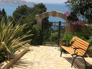 a bench sitting in a garden with the ocean in the background at Grlica in Bar