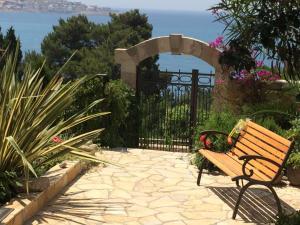 a bench sitting in a garden with a view of the ocean at Grlica in Bar +7 photos