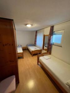 um pequeno quarto com 2 camas e uma janela em Villa Hercegovina em Sveti Filip i Jakov