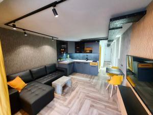 uma sala de estar com um sofá e uma cozinha em Stonefall Tenerife Holiday Apartment Las Americas em Playa Fañabe