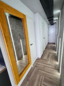 a hallway with a glass door and wood floors at Stonefall Tenerife Holiday Apartment Las Americas in Playa Fañabe
