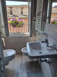 La salle de bains est pourvue d'un lavabo, de toilettes et d'une fenêtre. dans l'établissement hotel Bologna, à Fanano