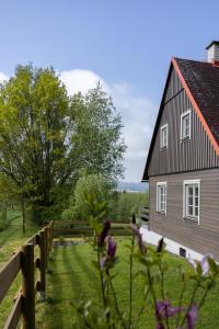 a barn with a fence and flowers in the foreground at Chata Šedivka in Dvůr Králové nad Labem