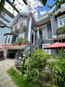 a blue house with a staircase in front of it at Căn Funny in Vung Tau