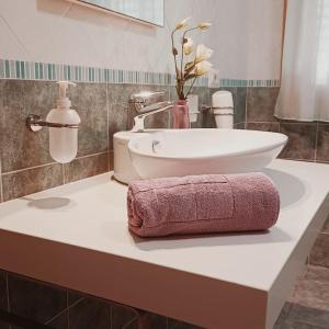 a bathroom sink with a pink towel on a counter at Sunny House Fourteen in Assemini