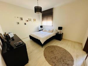 a bedroom with a bed and a table and a rug at Vacance in Ashkelon