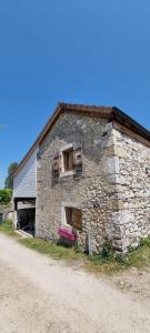 ein altes Steingebäude mit zwei Seitenfenstern in der Unterkunft Au vieux four à pain - Studio à louer in Chevry