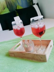two wine glasses on a wooden tray on a table at Ferienzimmer Waldzauber in Borkwalde