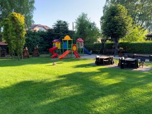 einen Park mit Spielplatz im Gras in der Unterkunft Dom wczasowy HEEP in Białogóra