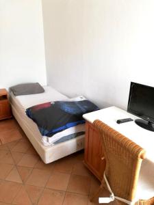a bedroom with a bed and a desk with a computer at Apartment in Nijmegen voor 3 personen in Kranenburg